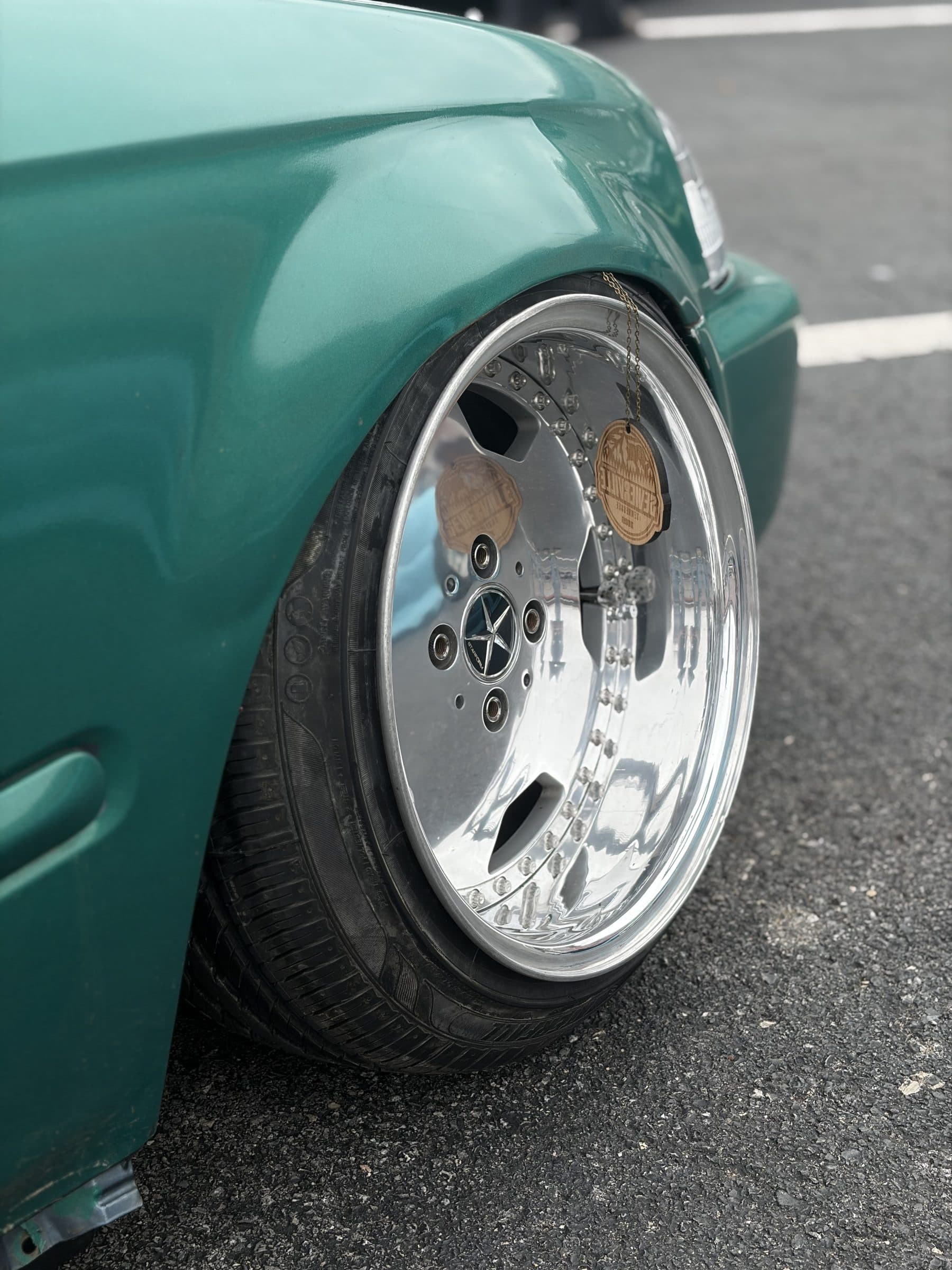 Close-up of the polished deep-dish wheel tucked under the fender of Garret's green Civic
