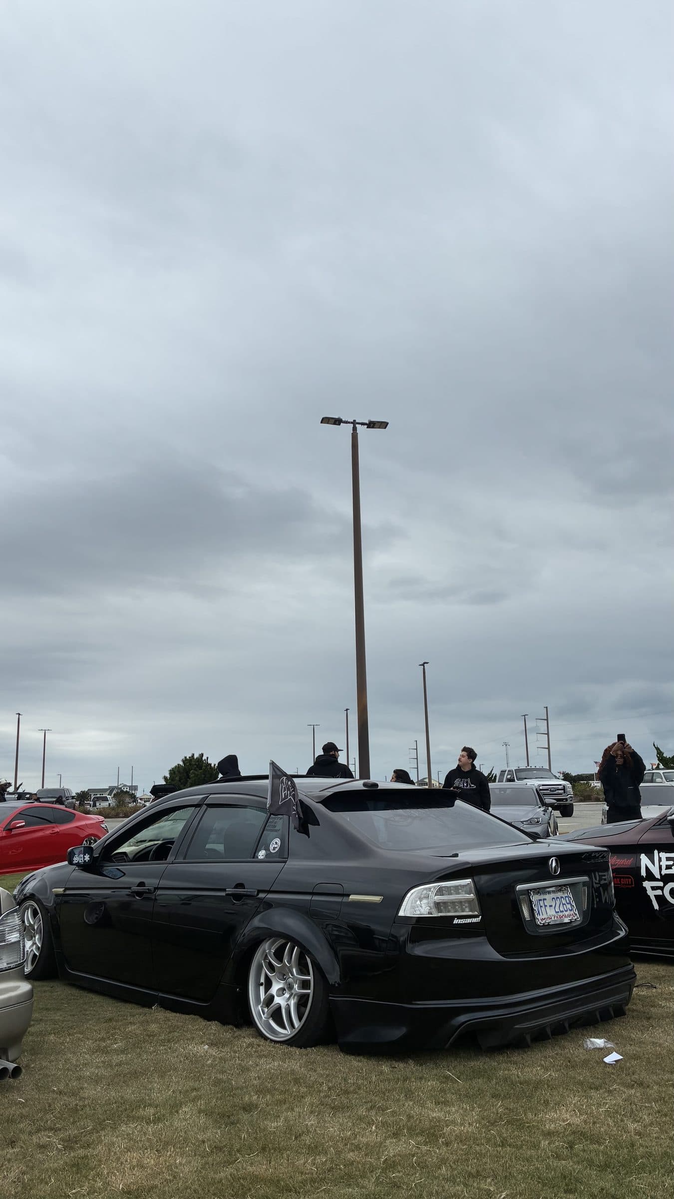 Rear view of Jonah's black Acura TL on the grass at a car show