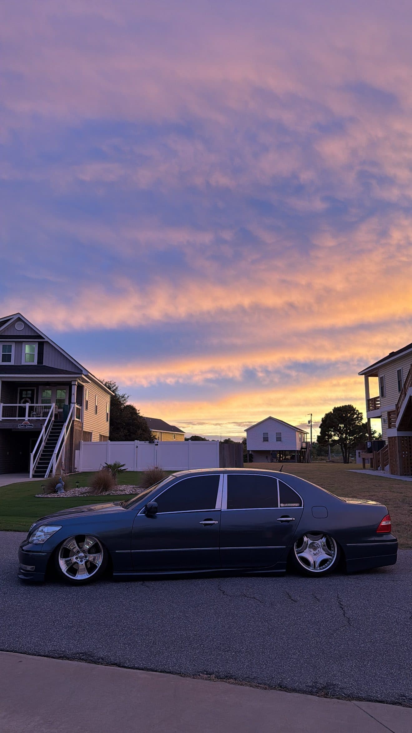 Side profile of Juan's grey Lexus LS430 sitting low on the street at dusk