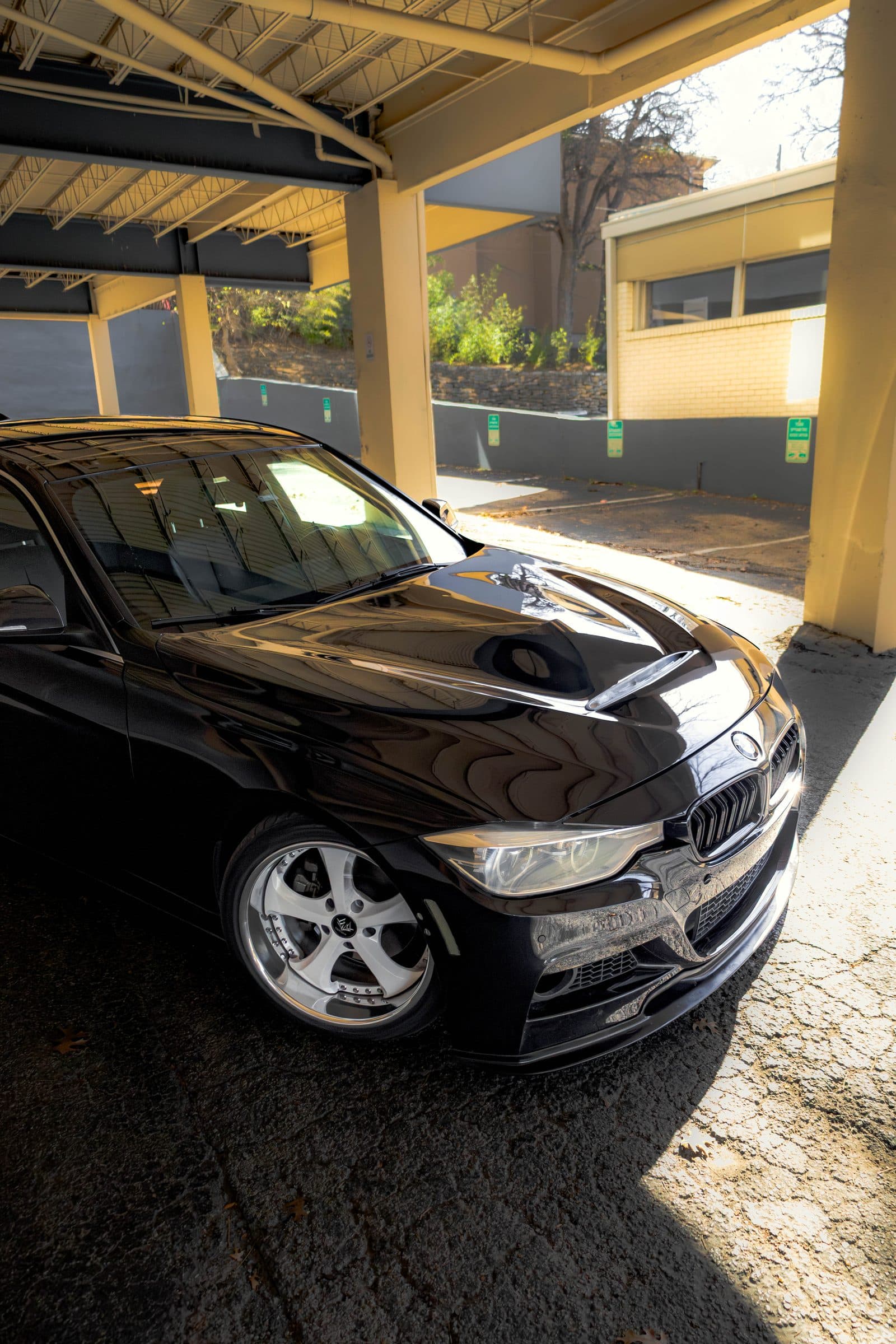 Front end of Keller's black BMW F30 under a loading-dock canopy