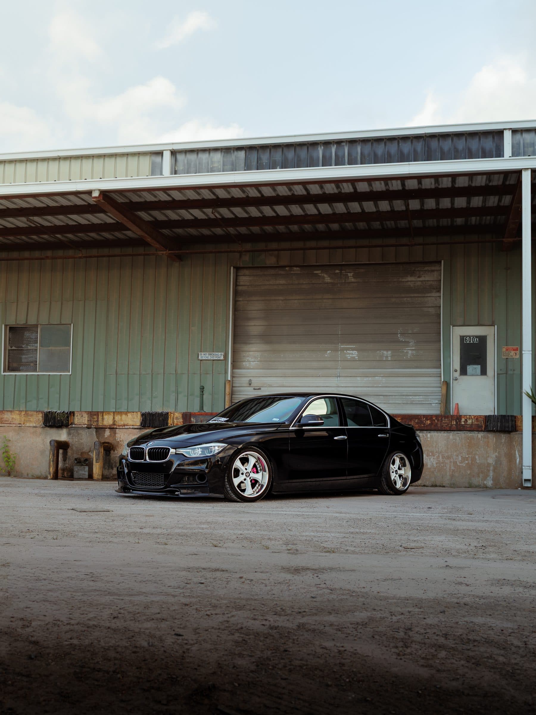 Keller's lowered black BMW F30 in front of a green warehouse