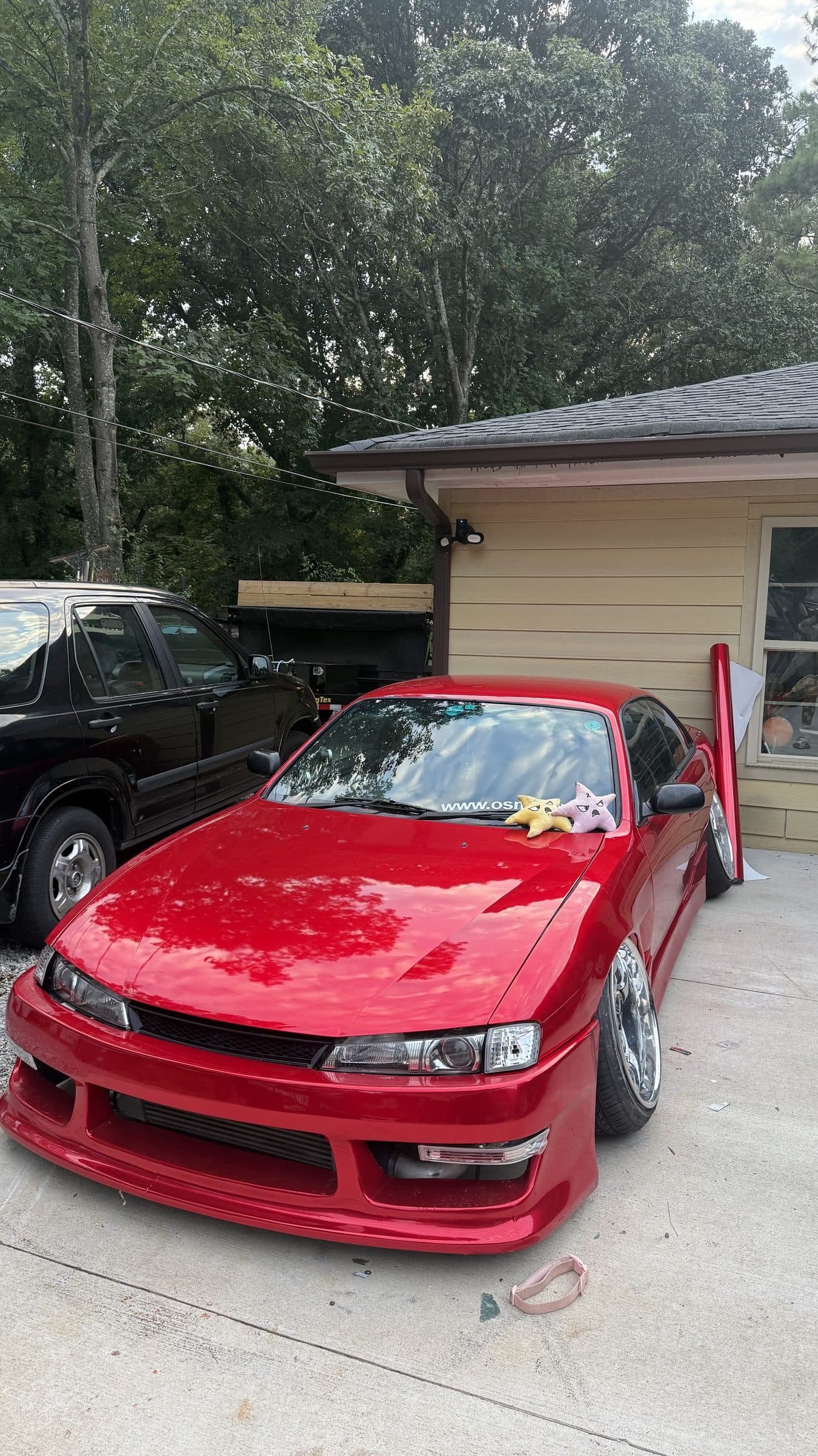 Front view of Torres's red Nissan S14 in a driveway