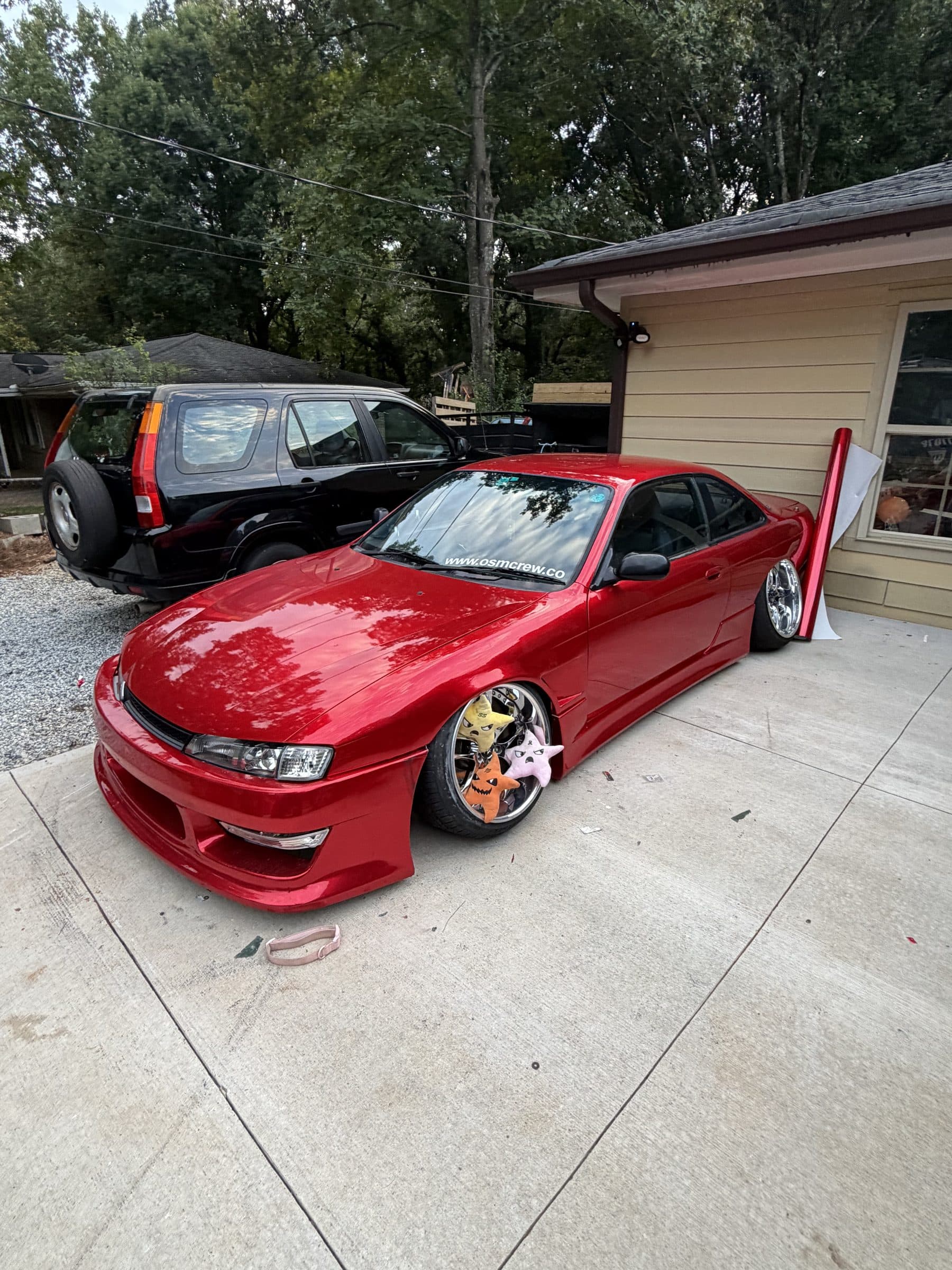 Front three-quarter view of Torres's red Nissan S14 in a driveway
