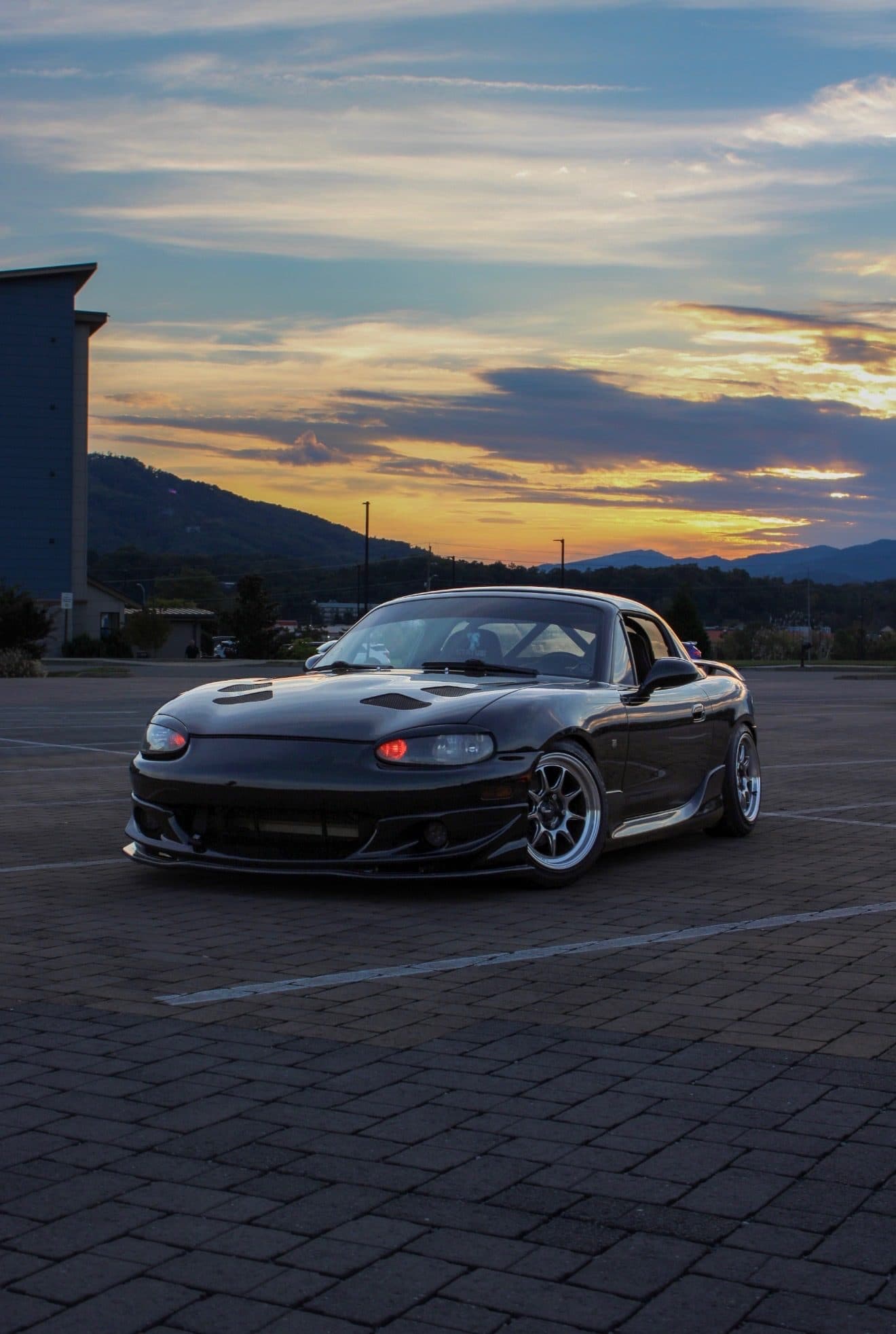 Front three-quarter view of Stephen's black NB Miata in a lot at sunset